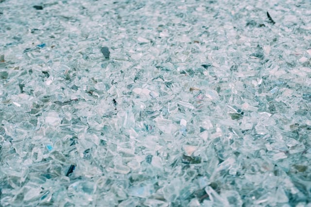 A layer of crushed clear and pale green glass cullet.