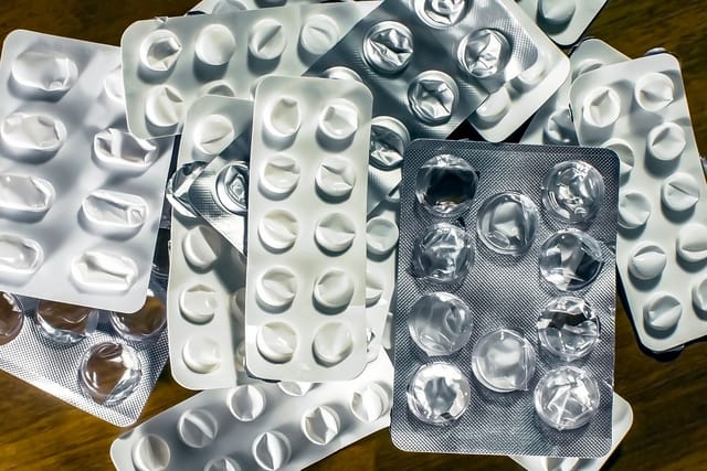 A pile of empty foil blister packs from tablets.