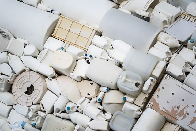 A tightly packed pile of white plastic tubs, pots and containers seen from above.